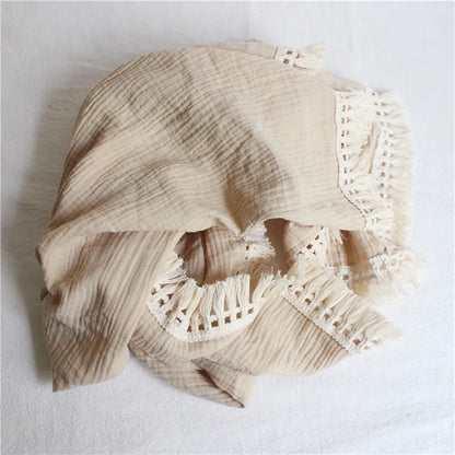 Cozy baby cotton swaddle blanket with tassel detail, ideal for infant receiving and nursery decoration