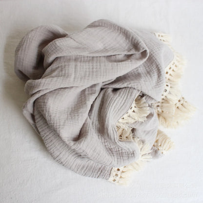 White cotton swaddle with playful tassels, essential newborn wrap for comfortable and secure swaddling