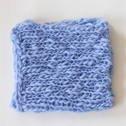 Hand-knitted cream baby blanket, a cozy and essential infant photo prop.