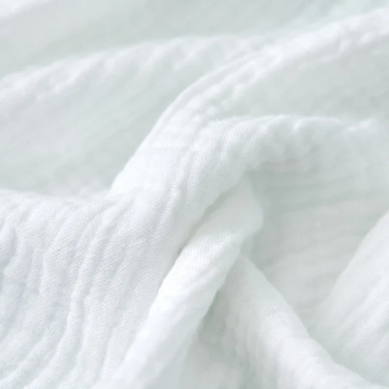 Eco-friendly cotton gauze diapers stacked on a changing table, sustainable baby choice
