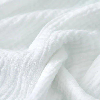Eco-friendly cotton gauze diapers stacked on a changing table, sustainable baby choice