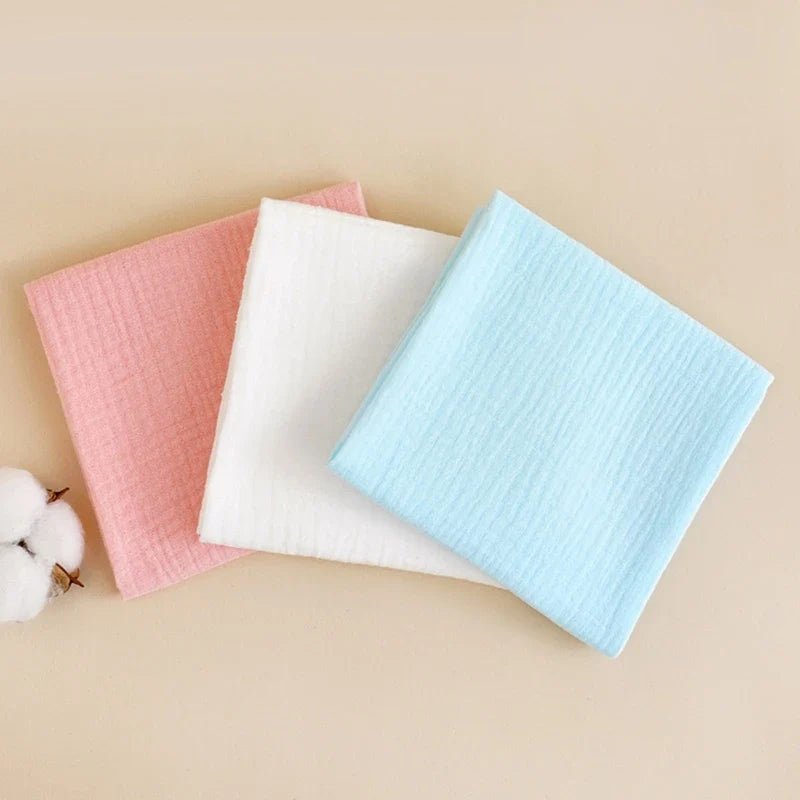 Stack of folded white reusable cotton gauze diapers, ideal for sustainable baby care