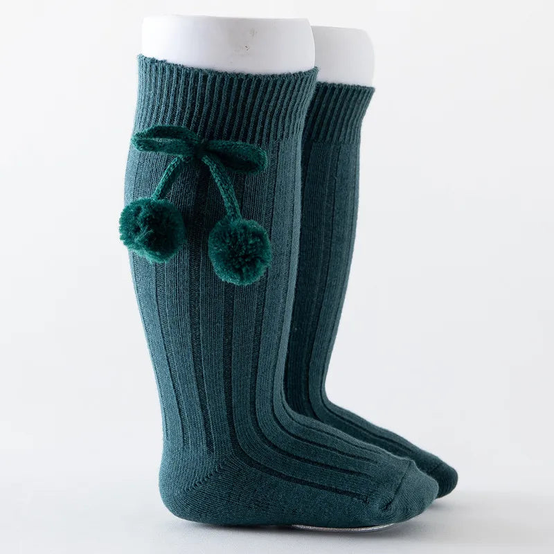Soft knit knee-high baby socks with elastic cuff for a snug fit.