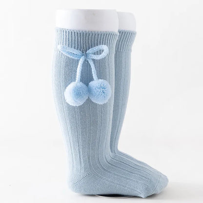 Baby playing while wearing soft knit knee-high socks, freedom of movement.