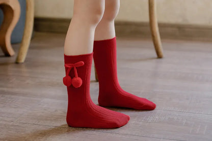 Baby girl's outfit with soft knit knee-high socks, complete look.