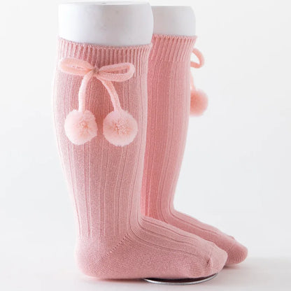 Close-up of a pair of soft knit knee-high baby socks, high quality cotton.