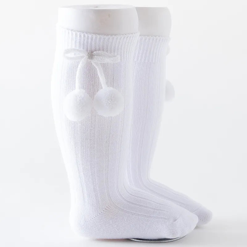 White soft knit knee-high baby socks, essential infant apparel.