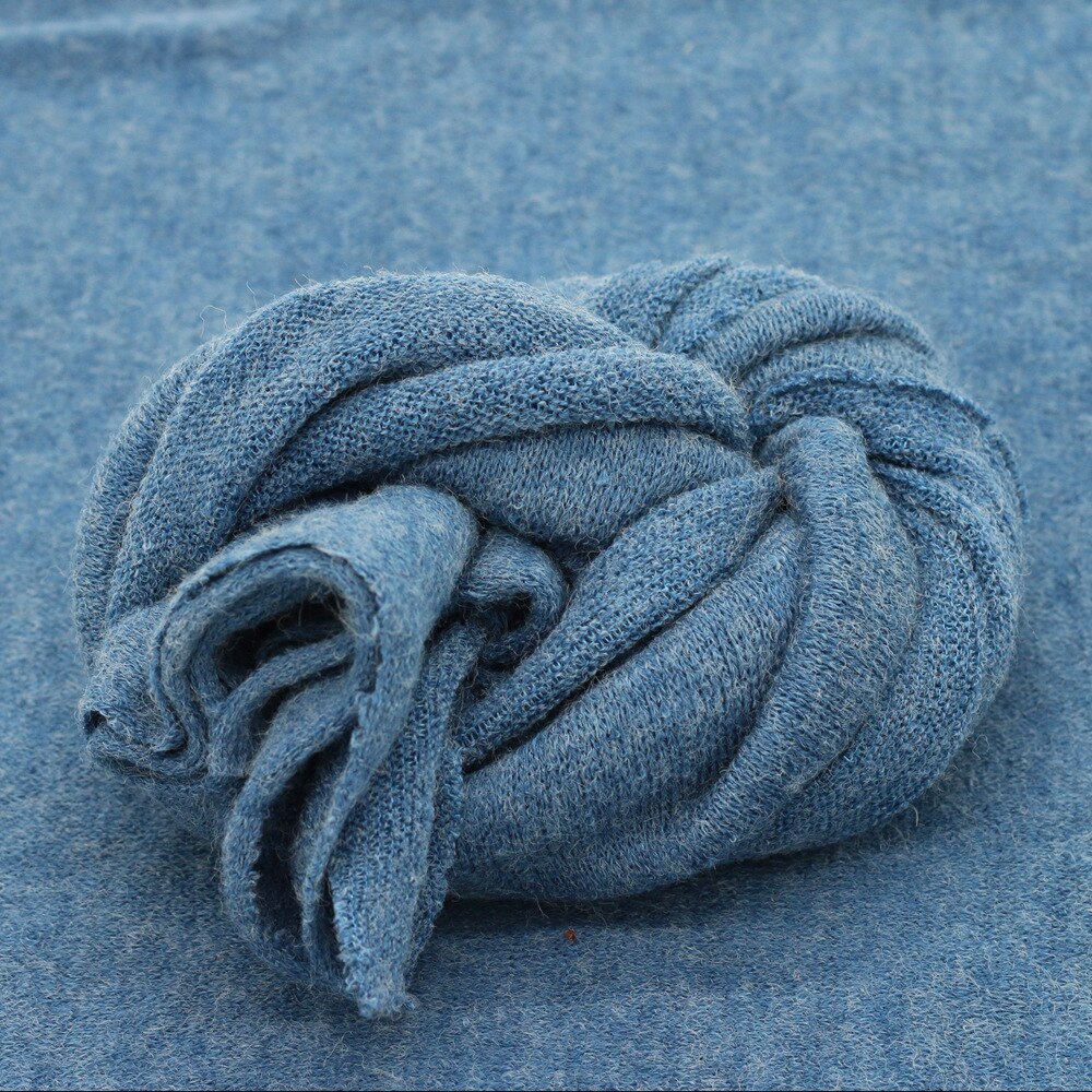 Hand-knitted baby blanket in natural white, ideal prop for newborn photography and baby decor backdrop.