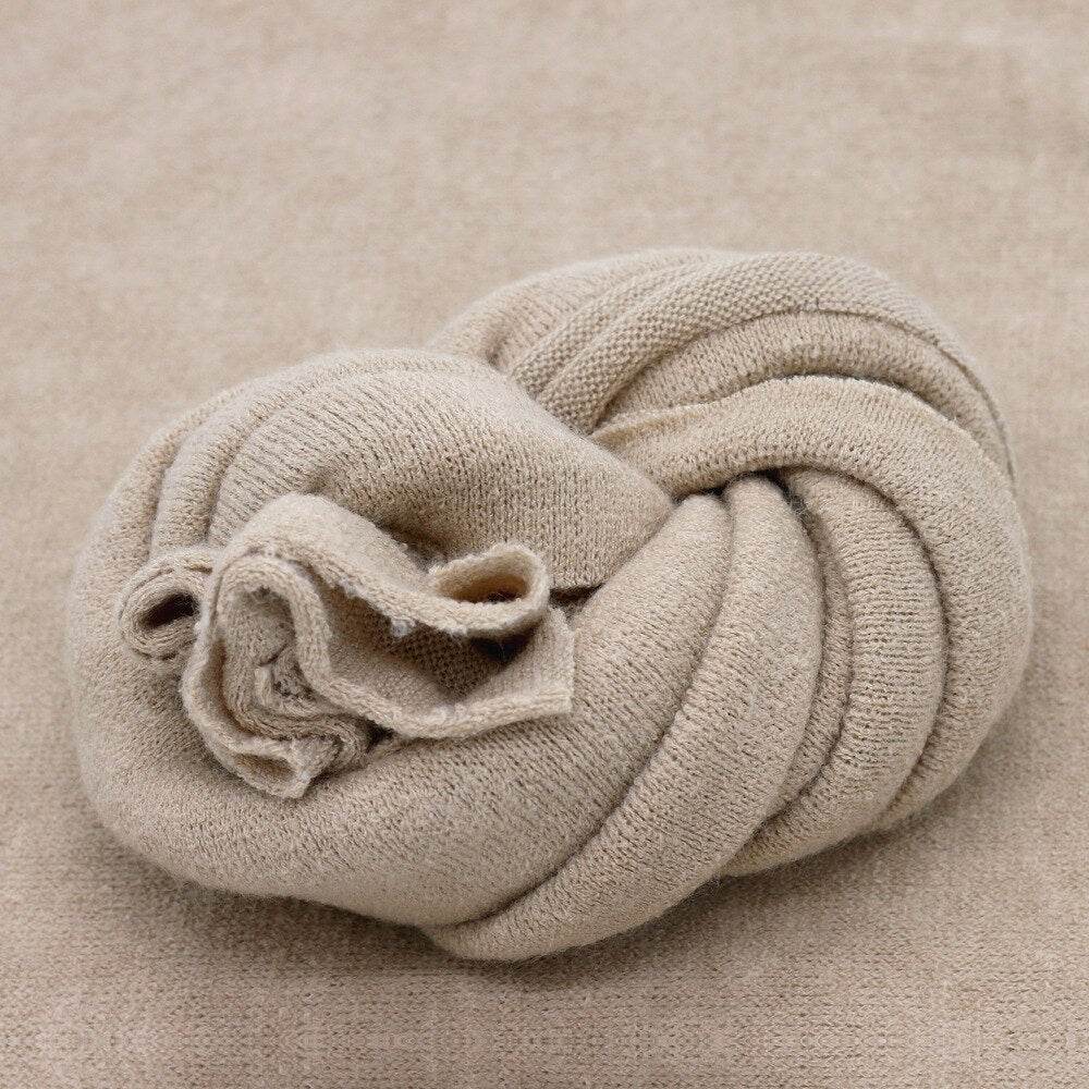 Versatile baby photography prop: off-white knitted blanket for wrapping or studio backdrop comfort.