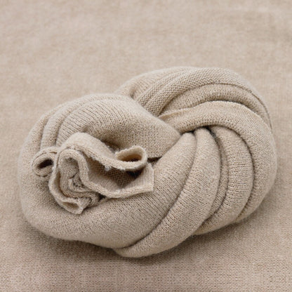 Versatile baby photography prop: off-white knitted blanket for wrapping or studio backdrop comfort.