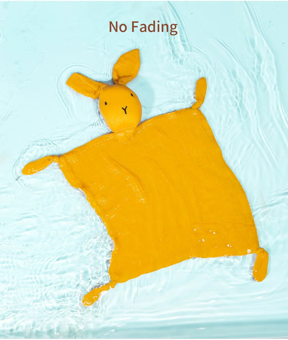 Folded muslin baby comfort towel, showing its compact size and delicate fabric.