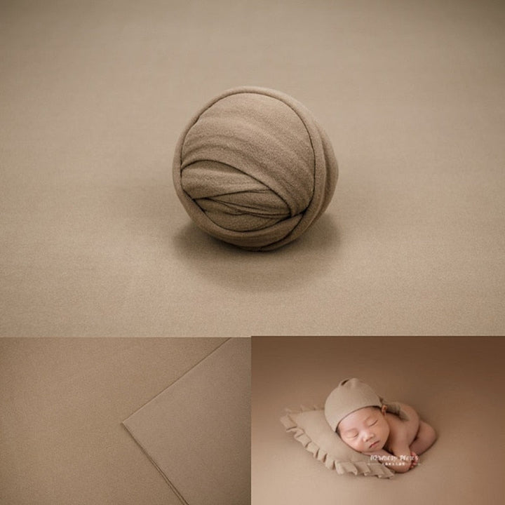 Bundle of newborn wraps in various colors with a portable backdrop prop
