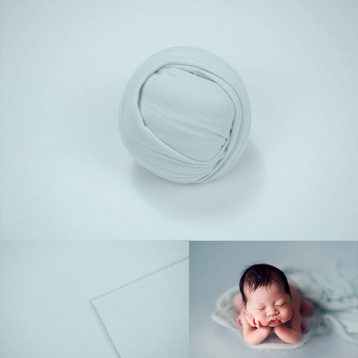 Detailed texture of a knitted newborn photography wrap, studio backdrop behind