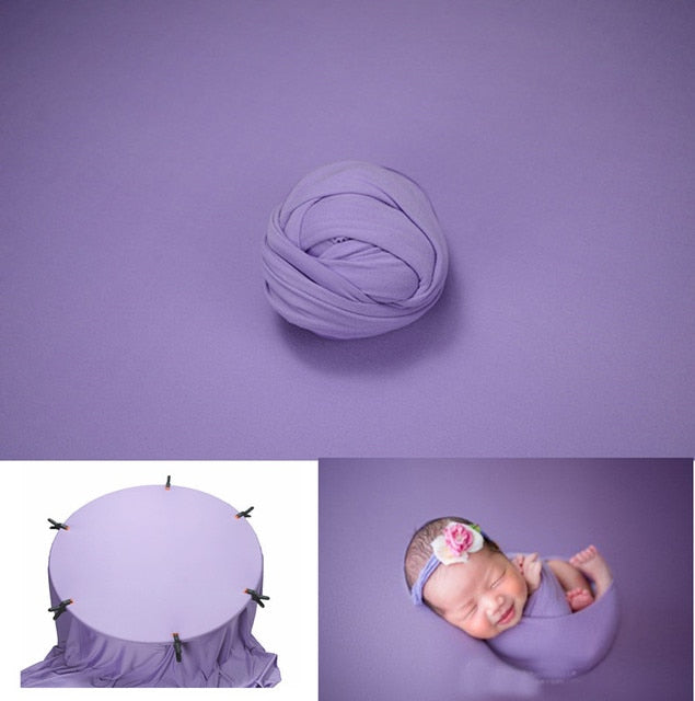 Infant photo prop: soft blue newborn wrap draped over a rustic wooden backdrop