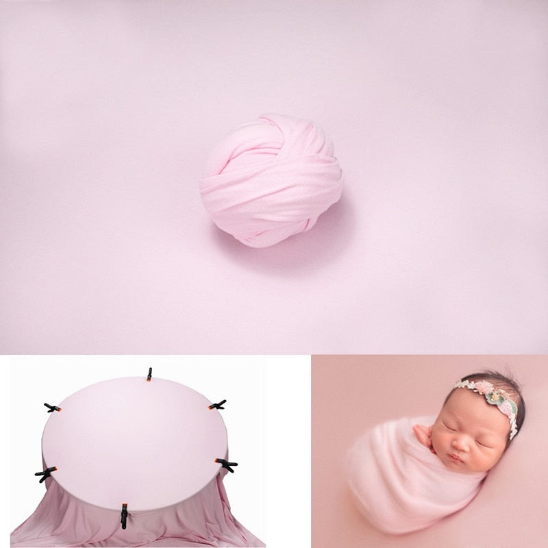 Assortment of colorful newborn wraps arranged with a plain white backdrop