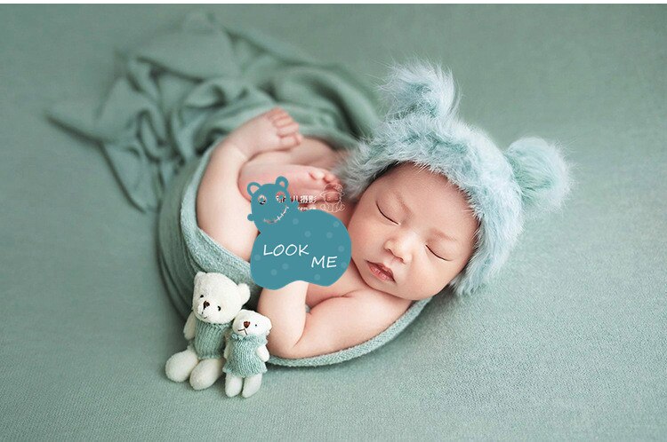 Newborn photography prop set: cozy swaddle blanket, tiny hat, and cute matching doll for infants.