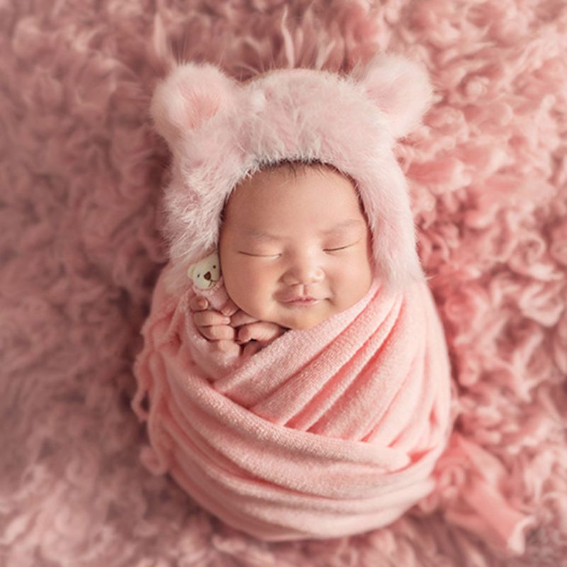 Cute baby photography prop set: plush swaddle blanket, knit hat, and small doll for infants.