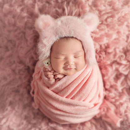 Cute baby photography prop set: plush swaddle blanket, knit hat, and small doll for infants.
