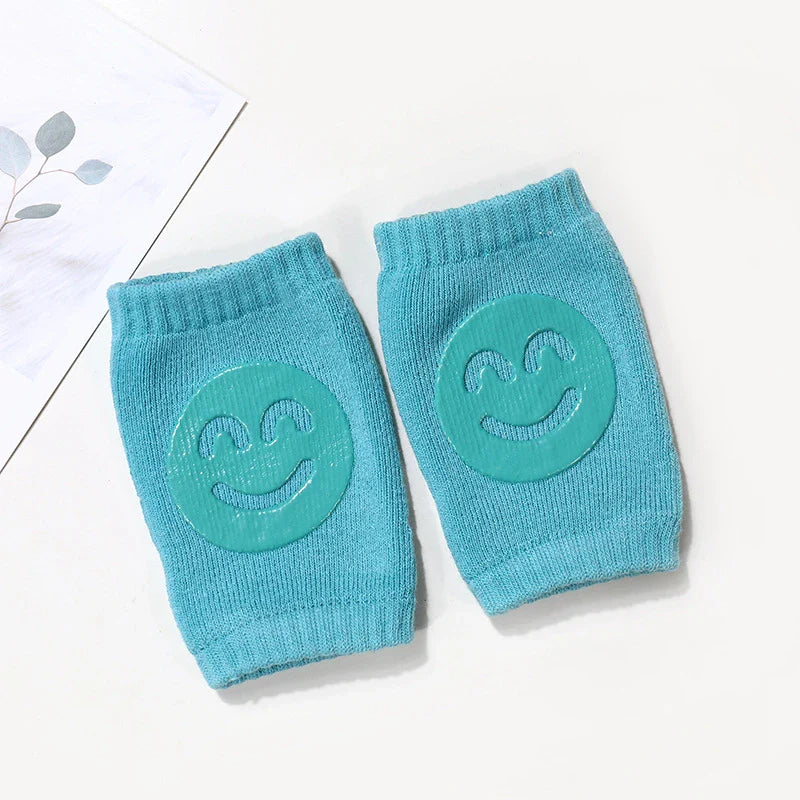 Display of various baby knee pads in retail packaging, highlighting their 'safe & soft' features.
