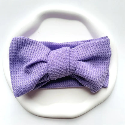 Infant girl sleeping peacefully with a lavender cotton bow headband on