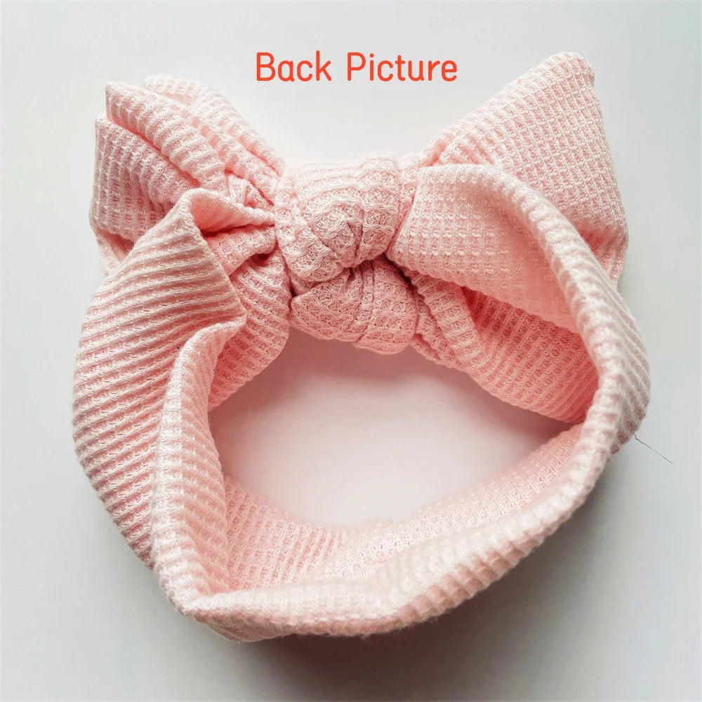 White baby girl cotton headband featuring a charming, delicate bow