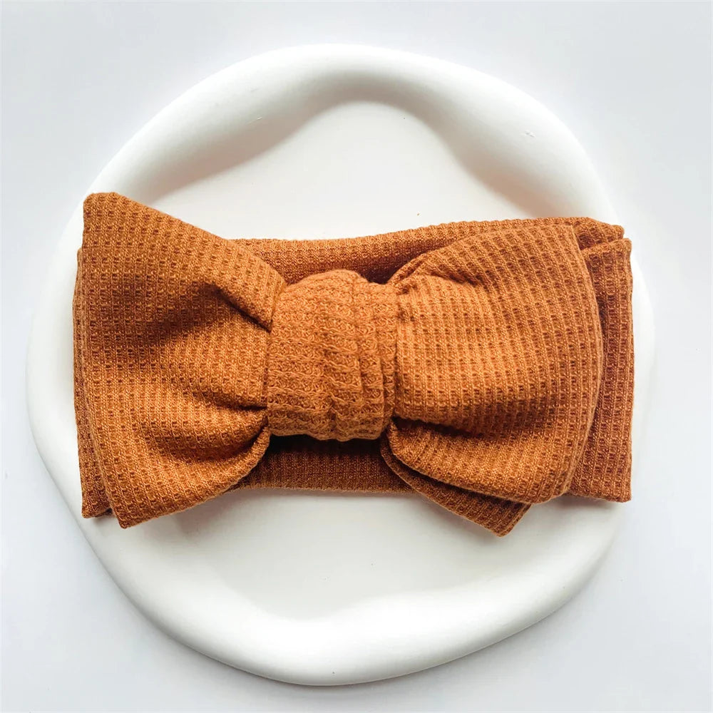 Mint green cotton baby headband with a playful bow, best for girls