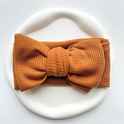 Mint green cotton baby headband with a playful bow, best for girls