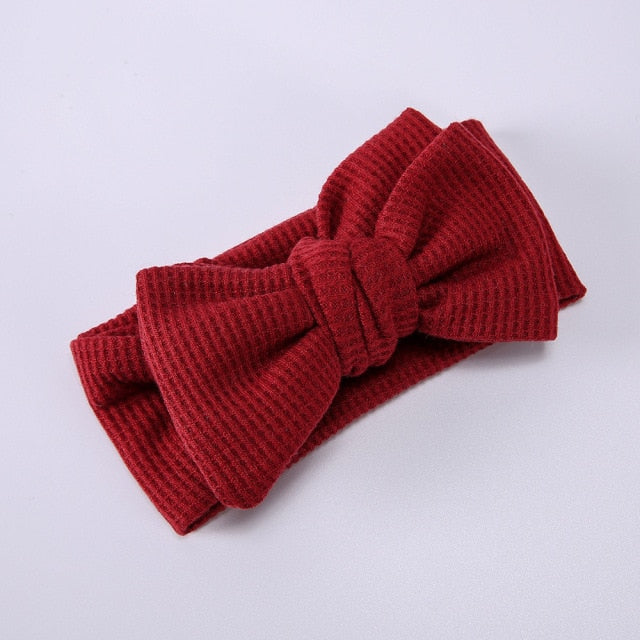 Close-up of a pink soft elastic bow headband, showcasing fabric details