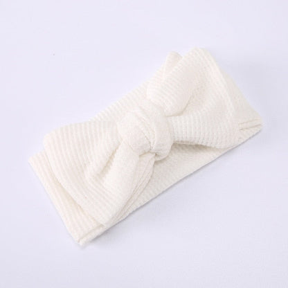 Baby girl wearing a red elastic bow headband, cute and fashionable infant