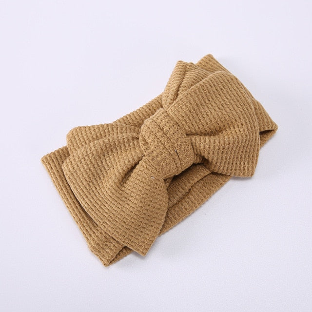 A collection of colorful elastic bow headbands for baby girls, newborn gifts