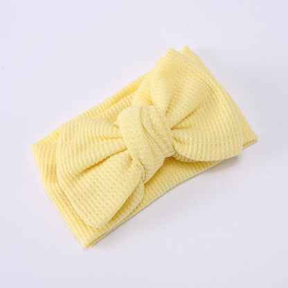 Soft pink baby elastic bow headband on a white background, product shot