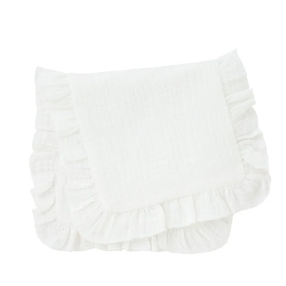 Hand holding a folded muslin burp cloth with ruffle edge, showcasing its soft texture for baby's skin.