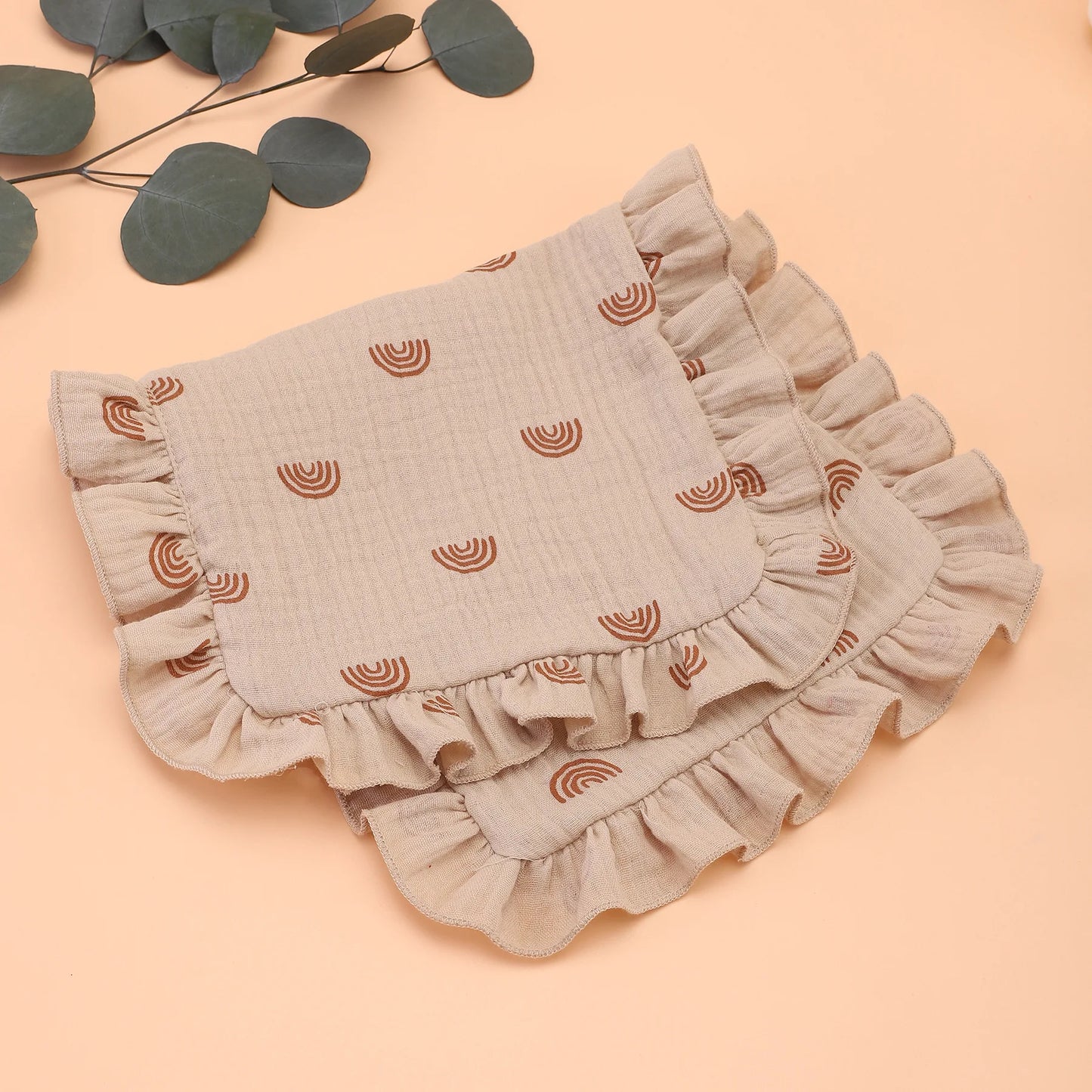 Cream colored muslin cotton burp cloth with subtle ruffle, a gentle shoulder rag for infant care essentials.