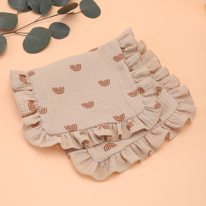 Cream colored muslin cotton burp cloth with subtle ruffle, a gentle shoulder rag for infant care essentials.