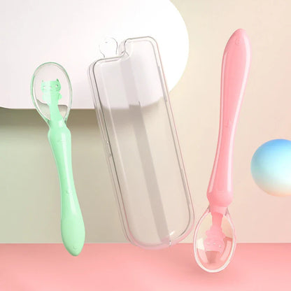 Toddler holding a blue silicone feeding spoon, practicing self-feeding skills