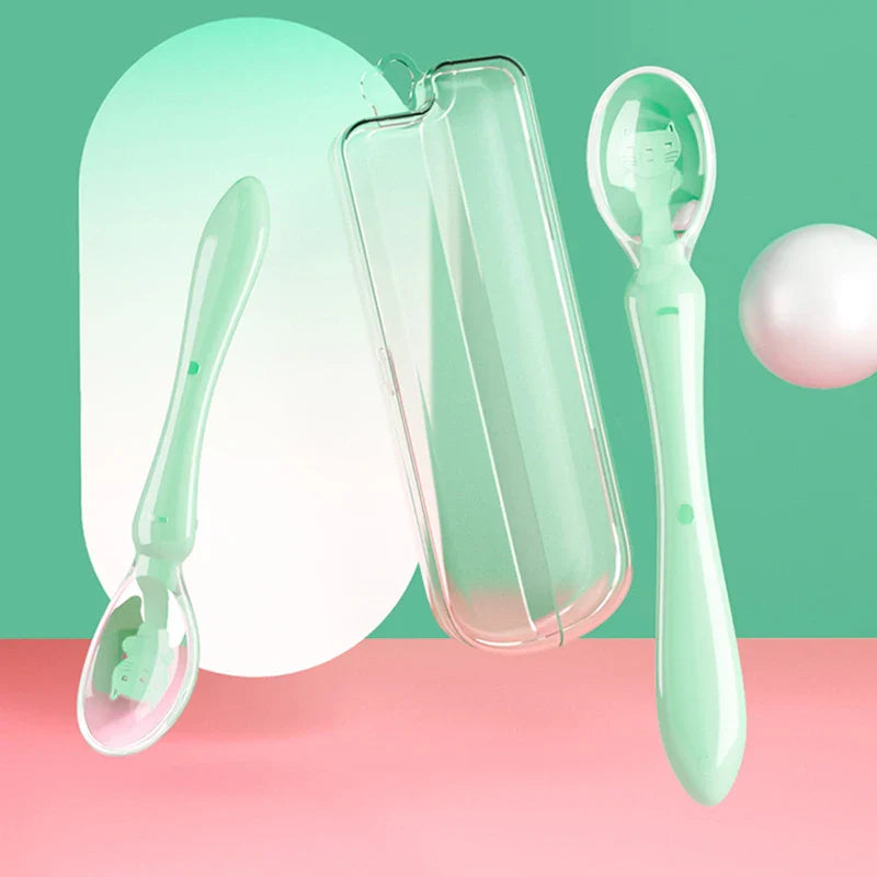 Infant eating with a green soft tip silicone spoon, encouraging baby led weaning