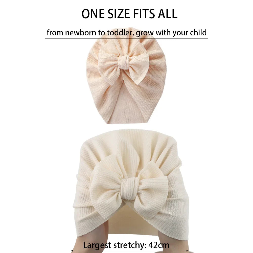 Baby wearing a yellow topknot turban, comfortable infant hat for newborn essentials