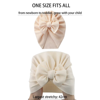 Baby wearing a yellow topknot turban, comfortable infant hat for newborn essentials