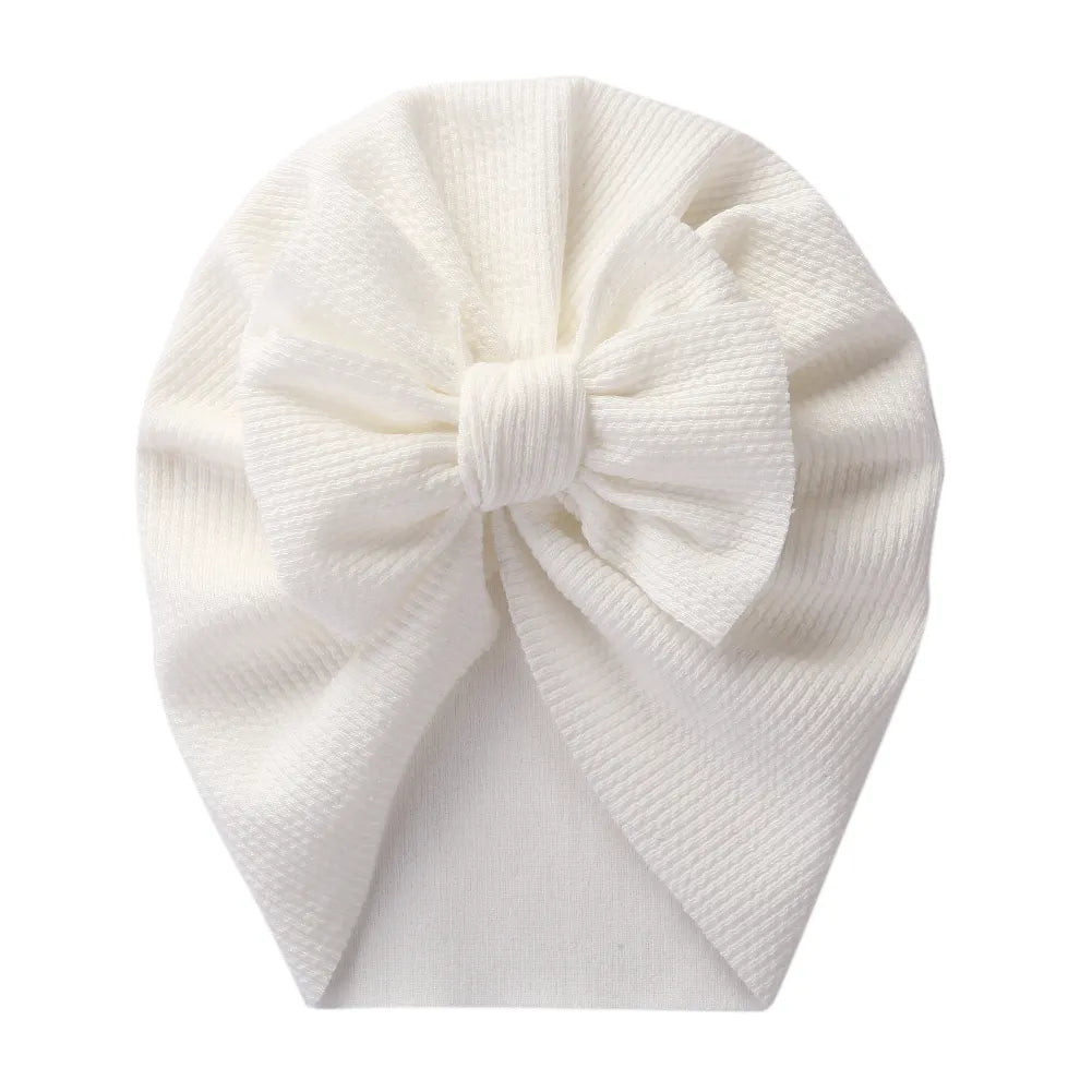 Infant in a patterned topknot turban, fashionable polyester baby headwrap accessory