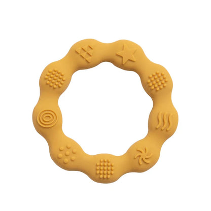 Baby holding an easy-grip silicone teether, promoting independent oral exploration