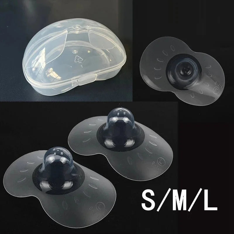 Closeup of a pair of clear silicone nipple shields, designed for breastfeeding pain relief and protection.