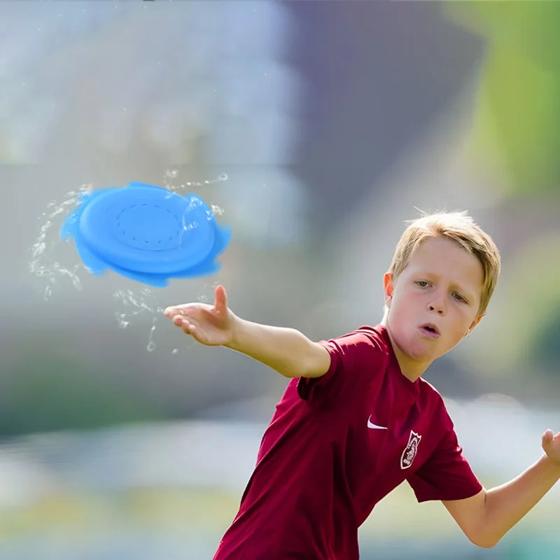 Soft silicone water frisbee, purple, on grass, indicating outdoor play and promoting motor skills for kids