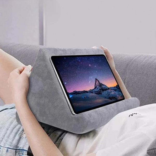 Soft tablet pillow stand for hands-free device viewing on bed or couch. Portable ergonomic holder & reading aid.