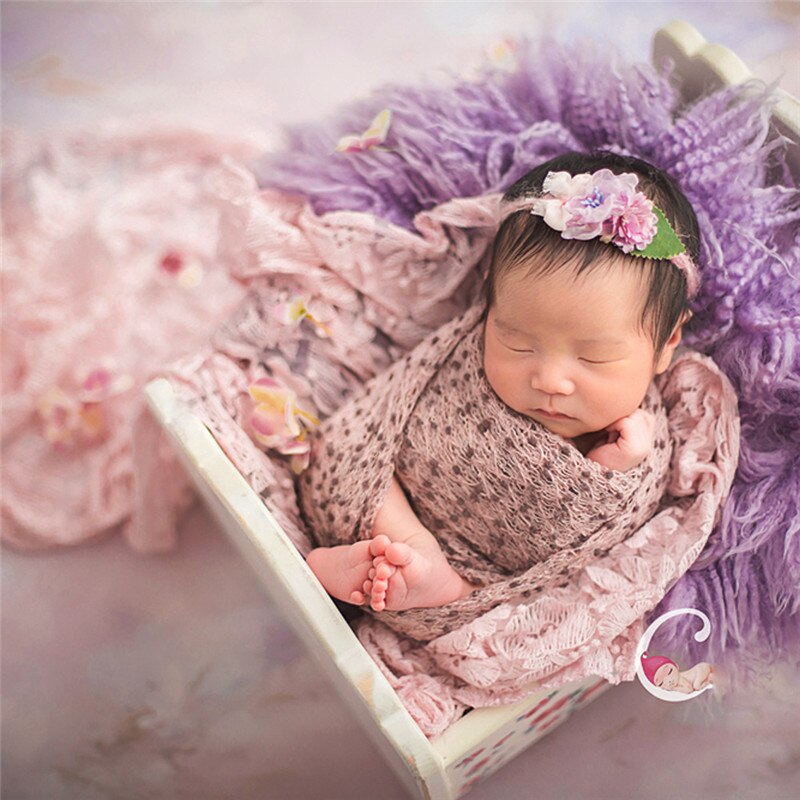 White cotton baby wrap and coordinating blanket, essential props for newborn photo sessions.