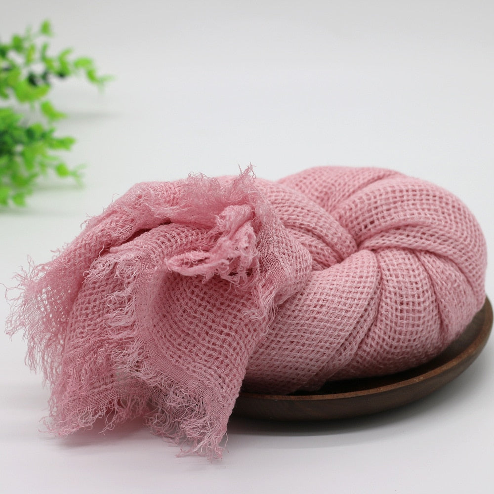 Grey cotton baby swaddle blanket with knot, ideal for newborn photography & comfortable infant sleep.