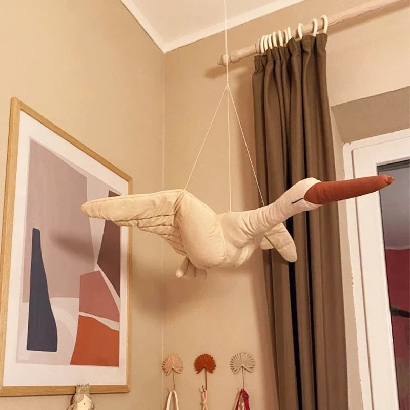 Elegant swan plush toy with gold crown, hanging on a wall, ideal as a baby room ornament.