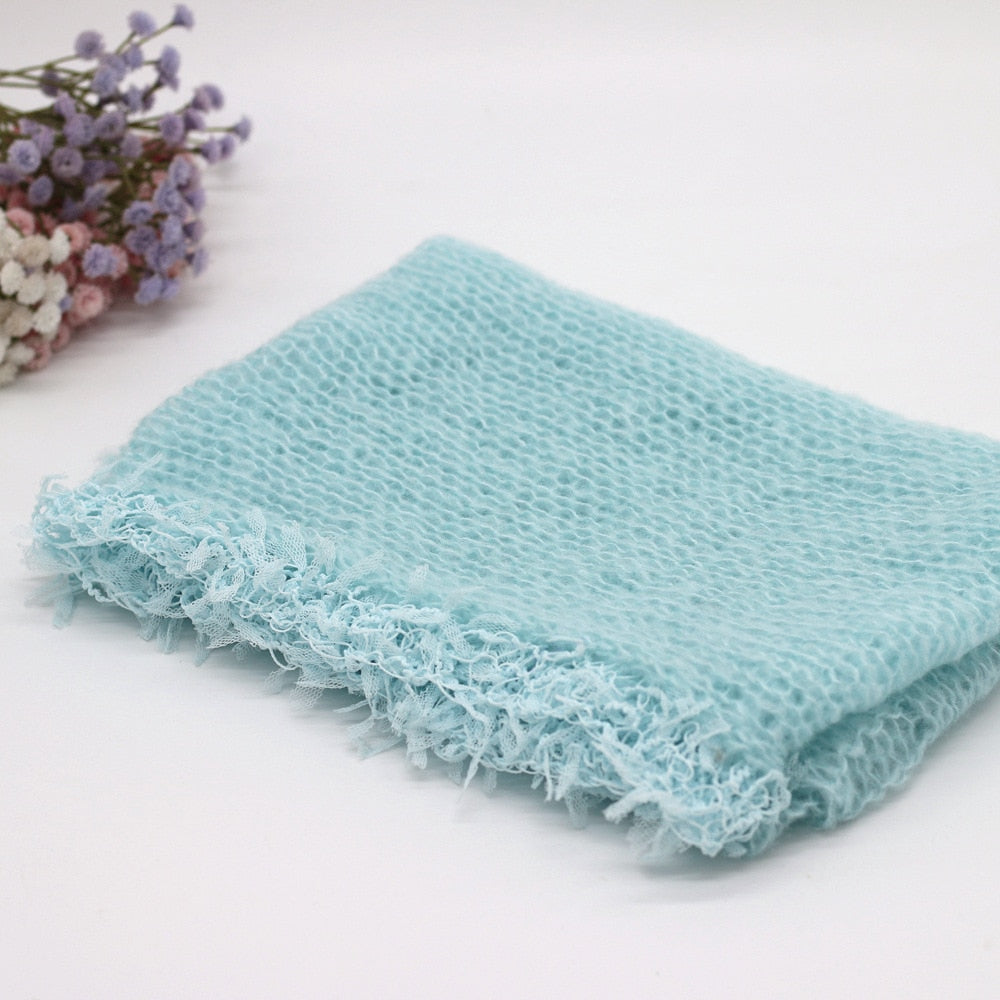 Close-up of a textured wool swaddle blanket, an essential newborn prop for baby photography backdrops.
