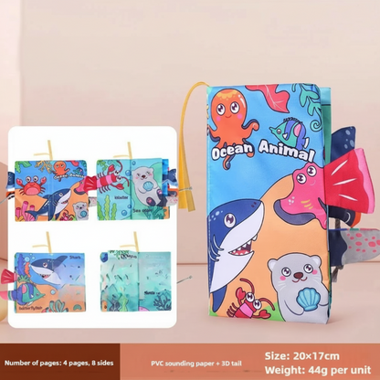 Happy baby looking at the interactive pages of a SoftTails fabric book, infant learning