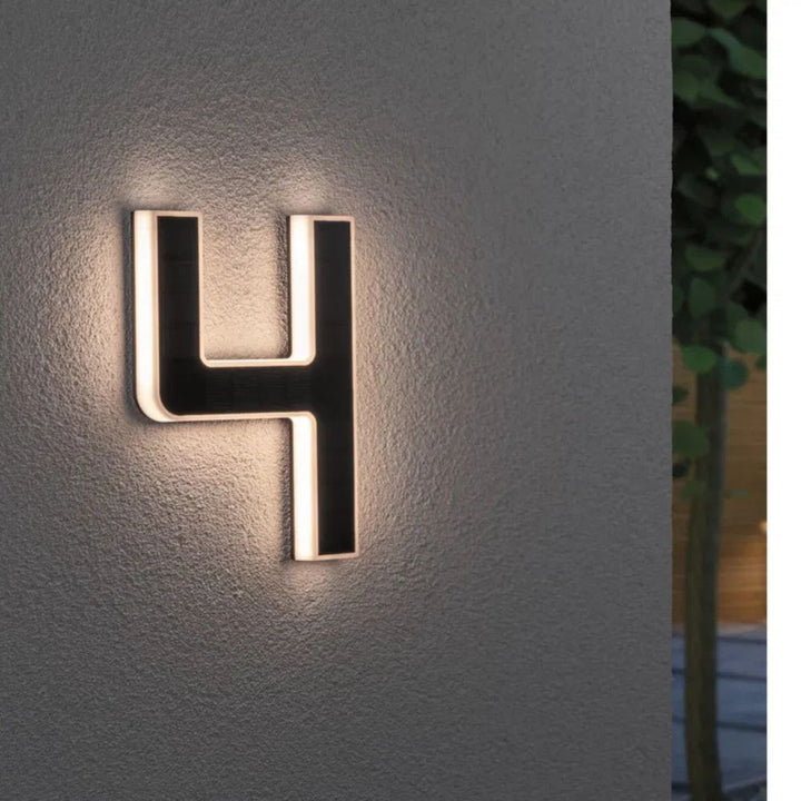 Bright LED house number sign, solar powered for a modern home exterior.