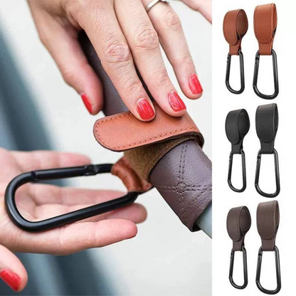 Detail shot of the strong clasp on a vegan leather stroller hook, securing baby gear.